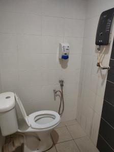 a bathroom with a toilet and a phone on the wall at Hotel Star Inn in Teluk Intan