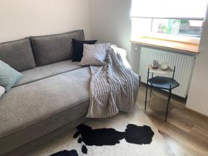uma sala de estar com um sofá e uma mesa com uma janela em Nibelungen Boardinghouse 1 Zimmer Apartment em Lindenfels