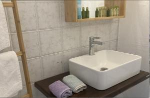 La salle de bains est pourvue d'un lavabo et de serviettes sur un comptoir. dans l'établissement Alonia Studios, à Firostefani