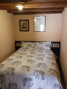 een slaapkamer met een bed met een witte sprei bij Casa rural TIO PEDRITO in Robledillo