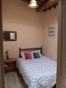 ein Schlafzimmer mit einem Bett und einem Nachttisch mit einem Bett von sidx sidx sidx sidx sidx in der Unterkunft Casa rural TIO PEDRITO in Robledillo