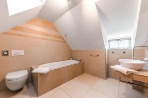 a bathroom with a sink and a toilet and a tub at Aparthotel Tycho de Brahe in Prague
