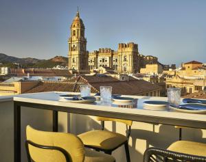 a table on a balcony with a view of a city at Vincci Larios Diez in Málaga