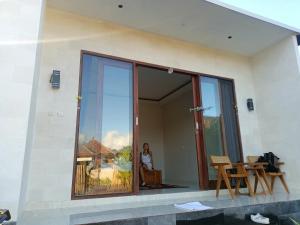 a woman standing in a window of a house at Mahadanu Kintamani Private Villa in Kintamani