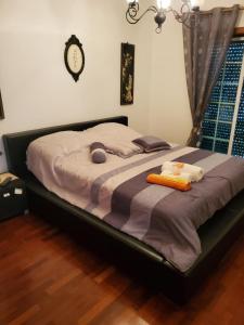 łóżko w sypialni z zegarem na ścianie w obiekcie Alojamento Bertil w mieście Nazaré