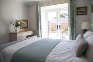 a bedroom with a large white bed with a window at Tresithick Vean Bed and Breakfast in Truro