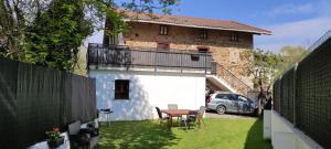 mały ogródek ze stołem i balkonem w obiekcie Alojamiento rural, jardín, a 25 minutos de Bilbao, parking gratuito w mieście Aránzazu Celaya
