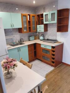 a kitchen with a table and a vase of flowers at OhMyHome Złota Colors in Warsaw