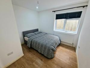 a small bedroom with a bed and a window at Mile End Budget Guesthouse in London