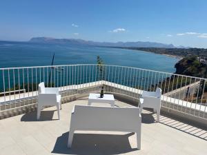 einen Balkon mit einem Tisch, Stühlen und Meerblick in der Unterkunft SOL Y MAR Camere e Appartamenti in Castellammare del Golfo