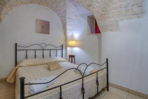 um quarto com uma cama num quarto com uma parede de pedra em Il Trulletto em Montalbano