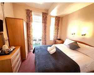 um quarto de hotel com uma cama e uma janela em Bonair Hotel em Paignton