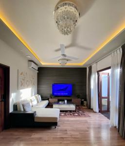 Isle Royal Inn في Fuvahmulah: غرفة معيشة مع أريكة وتلفزيون