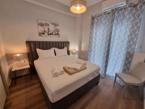 een slaapkamer met een bed met witte lakens en een stoel bij Athens' Secret Jewel in Athene