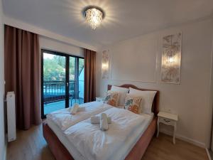 sypialnia z łóżkiem z białą pościelą i oknem w obiekcie Apartament In the Jungle Karpatia Resort w mieście Karpacz