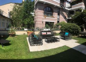 a yard with chairs and a bench in front of a house at Carlstadt Suites Düsseldorf in Düsseldorf