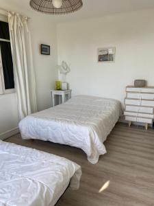 ein Schlafzimmer mit zwei Betten und einem Fenster in der Unterkunft Maison de vacances en bordure de mer ! in Batz-sur-Mer