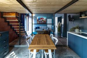 a dining room with a wooden table and white chairs at 147MqSuite in Santarcangelo di Romagna