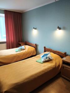 a hotel room with two beds and a window at Hotel Trias in Kyiv