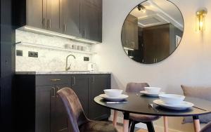 a kitchen with a table with chairs and a mirror at DK Premium Mendelsohna in Olsztyn