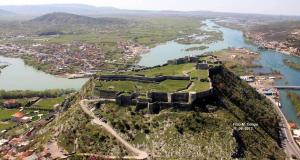 - une vue aérienne sur un château situé sur une colline à côté d'une rivière dans l'établissement Happy Corner Guest House, à Shkodër