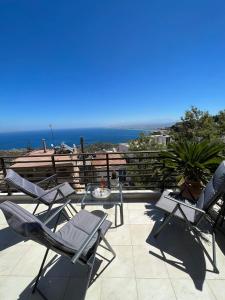 a patio with chairs and a table and the ocean at Horizon Art Villa in Rodia
