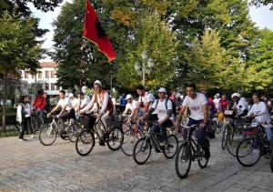 um grupo de pessoas andando de bicicleta por uma rua em Happy Corner Guest House em Shkodër