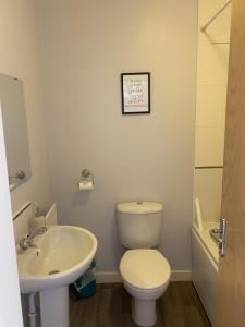 a bathroom with a toilet and a sink at Coventry City Centre townhouse with private parking in Coventry