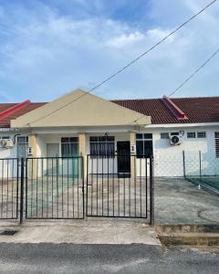 een wit huis met een hek ervoor bij ExHome Terengganu in Kuala Terengganu