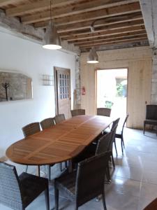 a large wooden table and chairs in a room at Gite de 6 à 14 pers avec Piscine-Jacuzzi- Salle des fêtes in Bastanès