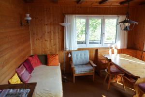 a room with a couch and a table and a window at Schwendihöckli - CharmingStay in Flumserberg