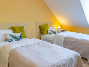 two beds in a room with yellow walls at Pensjonat Zielone Wzgórze in Lipiany