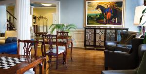 a living room with a table and chairs and a painting at The Marshall House, Historic Inns of Savannah Collection in Savannah