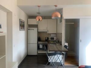 a kitchen with a table and a refrigerator at Nice apartment close to park Guell1 in Barcelona