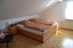 a bedroom with a bed and a chair and a window at Frankenau Fewo Kellerwald in Frankenau