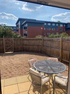 eine Terrasse mit einem Tisch, Stühlen und einem Zaun in der Unterkunft Coventry City Centre townhouse with private parking in Coventry