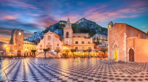 an old town with a mountain in the background at Casa Linda Taormina Etna in Fondachello