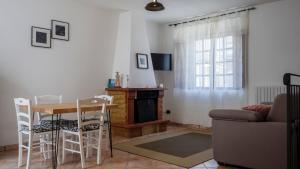 uma sala de estar com uma mesa e uma lareira em Alloggio del Vicolo - Le Vecchie Vasche em Coppito