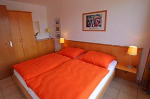 ウッカーミュンデにあるFerienwohnung Lagunenstadt VORP 2771のベッドルーム1室(オレンジのベッド1台、オレンジの枕2つ付)