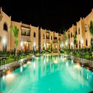Una gran piscina frente a un edificio por la noche. en Toubkal appart hotel, en Tahannout