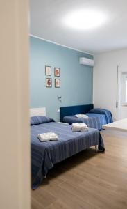 Duas camas num quarto com paredes azuis em Home 42 B&B em Terracina