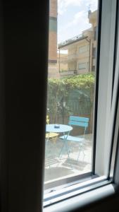 uma vista para uma mesa e cadeiras a partir de uma janela em Home 42 B&B em Terracina