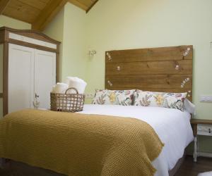 1 dormitorio con 1 cama grande y cabecero de madera en Vente a Babia en Torrebarrio
