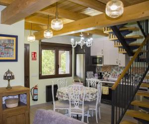 uma cozinha e sala de jantar com mesa e cadeiras em Vente a Babia em Torrebarrio