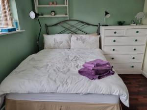 a bed with a purple blanket on it in a bedroom at Anerley-Crystal Palace in Sydenham