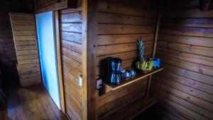 a room with a wooden wall with a shelf and a pineapple at White Wind Resort in Itarema