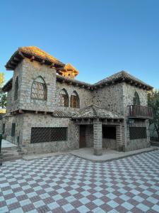a large stone building with a checkered floor at Alojamiento Rural La Moraleja in Villanueva del Arzobispo