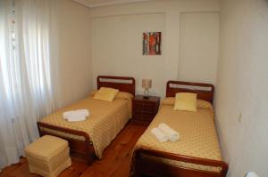 レイノサにあるApartamentos La Luz de Reinosa 2のベッドルーム1室(ベッド2台、ランプ付きテーブル付)