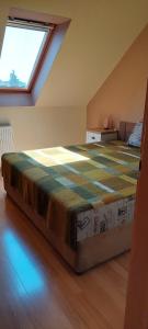 a large bed in a room with a window at Szikszai Apartman in Balatonfůzfő