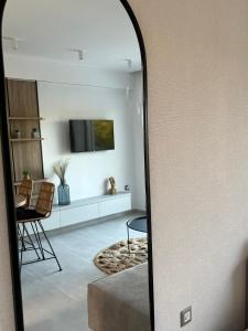 a mirror in a living room with a tv at Aelia Apartments in Makry Gialos